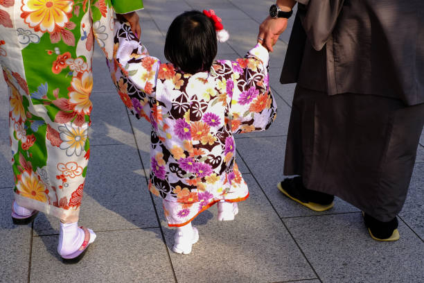 Japanese family walk together in traditional Japanese clothing at the old Asakusa Kannon Sensoji temple in the heart of Tokyo.